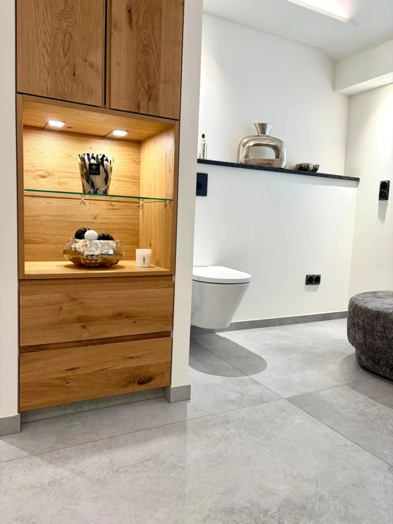 Badezimmer mit Einbauregal aus Eiche und hellgrauen Großformat-Bodenfliesen