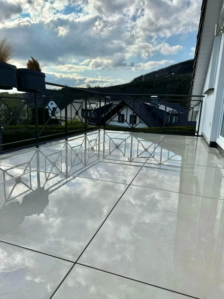 Balkon mit großformatigen Feinsteinzeugfliesen und Blick auf die Hügel