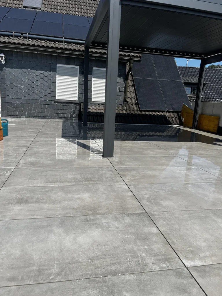 Dachterrasse mit großformatigen Terrassenplatten und Pergola