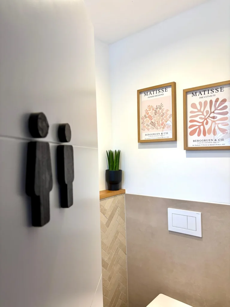Gäste-WC mit beigen Wandfliesen und Fischgrät-Verlegung in Holzoptik