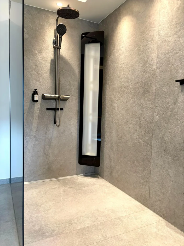 Bodengleiche Walk-in-Dusche mit großformatigen Wandfliesen in Steinoptik