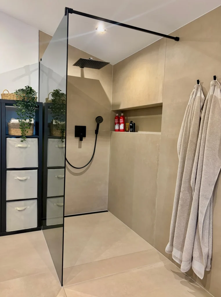 Walk-in-Dusche mit gefliester Wandnische und schwarzen Armaturen